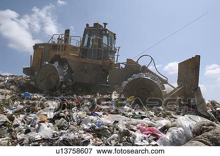 Digger working at landfill site View Large Photo Image Stock Photo - Digger working at landfill site. Fotosearch