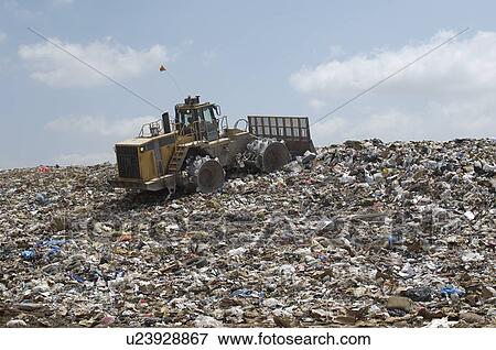 Stock Photo - Digger working at landfill site. Fotosearch
