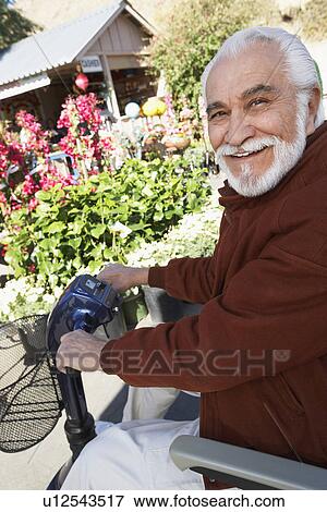 Stock Photo - Elderly man on motor scooter. Fotosearch