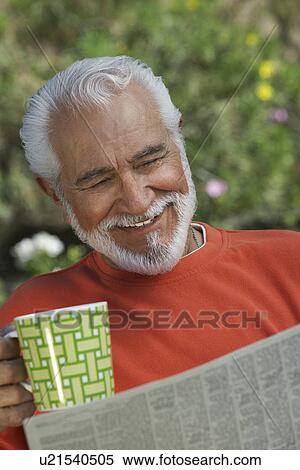 Stock Photography - Elderly man reading newspaper outdoors. Fotosearch