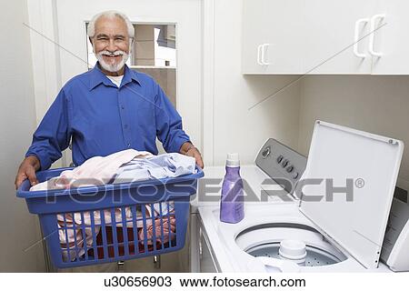 Stock Image - Elderly man with laundry basket. Fotosearch
