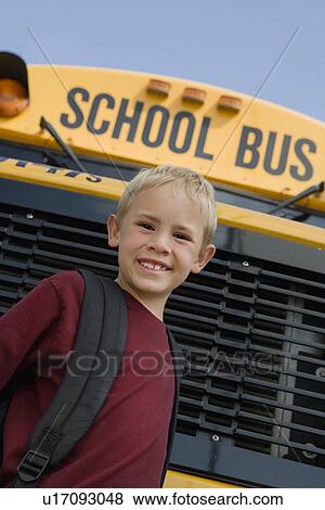 Stock Photo - Elementary Student Standing by School Bus. Fotosearch