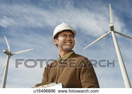 Engineer near wind turbines at wind farm View Large Photo Image Stock Photograph - Engineer near wind turbines at wind farm. Fotosearch