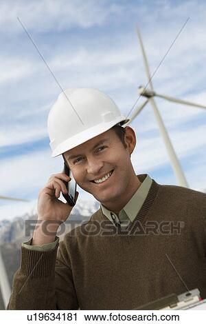 Engineer using mobile phone at wind farm, portrait View Large Photo Image Stock Image - Engineer using mobile phone at wind farm, portrait. Fotosearch