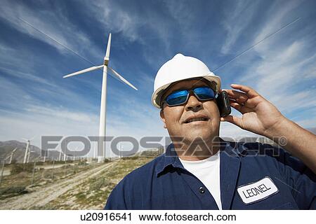 Engineer using mobile phone at wind farm, portrait View Large Photo Image Stock Image - Engineer using mobile phone at wind farm, portrait. Fotosearch