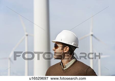 Engineer wearing hardhat at wind farm View Large Photo Image Stock Photo - Engineer wearing hardhat at wind farm. Fotosearch