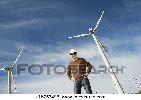 Engineer wearing hardhat at wind farm, portrait View Large Photo Image Stock Photo - Engineer wearing hardhat at wind farm, portrait. Fotosearch