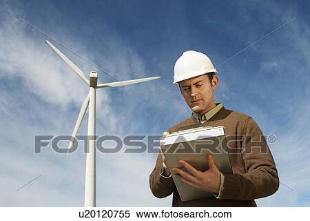 Engineer working near wind turbine at wind farm View Large Photo Image Stock Photography - Engineer working near wind turbine at wind farm. Fotosearch