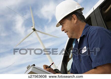 Engineer writing on clipboard by car at wind farm View Large Photo Image Stock Photo - Engineer writing on clipboard by car at wind farm. Fotosearch