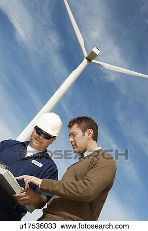 Stock Image - Engineers working at wind farm. Fotosearch