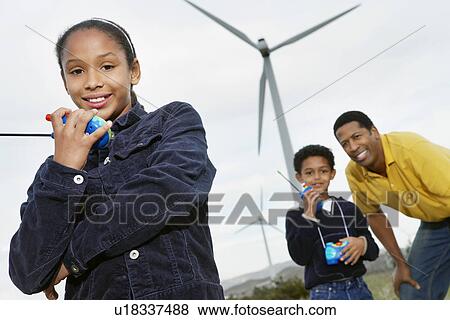 Father and children (7-9) playing with walky-talkies at wind farm View Large Photo Image Stock Photo - Father and children (7-9) playing with walky-talkies at wind farm. Fotosearch
