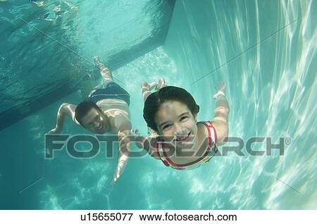 Stock Photo - Father and daughter swimming, underwater view. Fotosearch