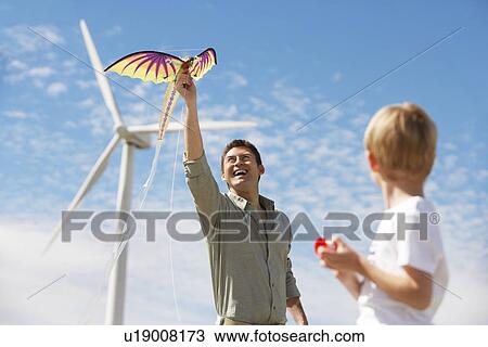 Father and son (7-9) playing with kite at wind farm View Large Photo Image Stock Image - Father and son (7-9) playing with kite at wind farm. Fotosearch