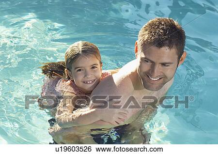 Father giving daughter piggy back in swimming pool View Large Photo Image Stock Photograph - Father giving daughter piggy back in swimming pool. Fotosearch