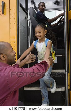 Stock Image - Father Picking Daughter Up at Bus Stop. Fotosearch