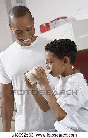 Father watching son (7-9) drinking milk, indoors View Large Photo Image Stock Image - Father watching son (7-9) drinking milk, indoors. Fotosearch