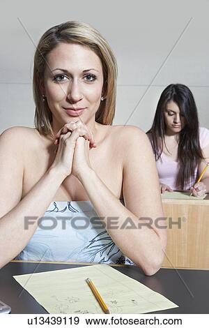 Stock Photo - Female student sitting in class, portrait. Fotosearch
