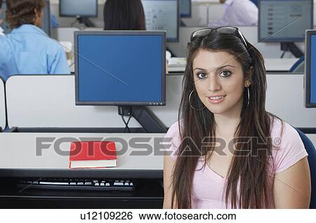 Stock Photograph - Female student sitting in computer classroom, portrait. Fotosearch