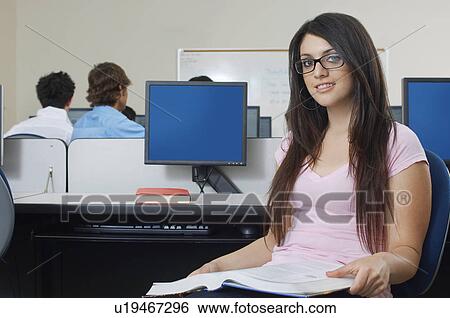 Stock Photograph - Female student sitting in computer classroom, portrait. Fotosearch