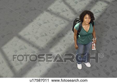 Stock Image - Female student smiling, indoors, portrait. Fotosearch