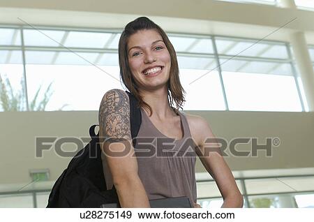 Stock Photo - Female student smiling, indoors, portrait. Fotosearch