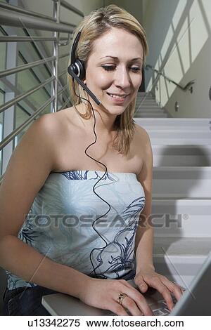 Female student using laptop with headset on stairs View Large Photo Image Stock Photography - Female student using laptop with headset on stairs. Fotosearch