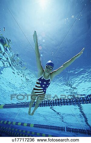 Stock Photograph - Female swimmer wearing United States swimsuit, swimming in pool. Fotosearch