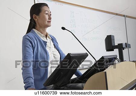 Stock Photo - Female teacher in lecture theatre. Fotosearch