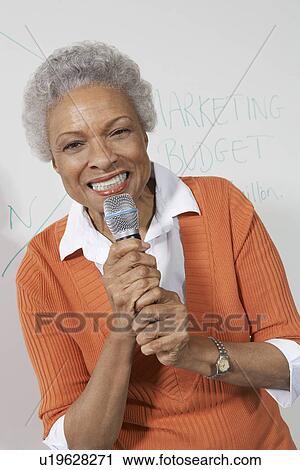Female teacher using microphone near white board View Large Photo Image Stock Image - Female teacher using microphone near white board. Fotosearch