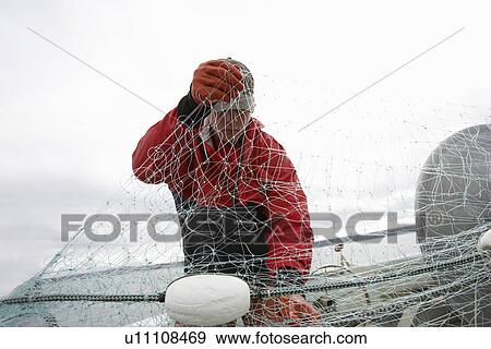 Fisherman holding fishing net on boat View Large Photo Image Stock Photo - Fisherman holding fishing net on boat. Fotosearch