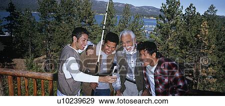 Stock Photo - Four men posing for self portrait on balcony. Fotosearch