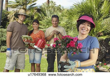 Four people gardening, focus on woman with flower in foreground View Large Photo Image Stock Photo - Four people gardening, focus on woman with flower in foreground. Fotosearch