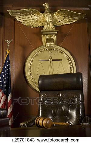 Stock Image - Gavel near judges chair in court room. Fotosearch