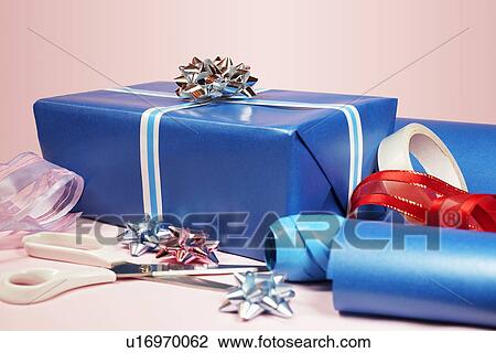 Stock Image - Gift with scissors, tape and ribbons. Fotosearch