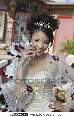 Stock Photo - Girl (13-15) using mobile phone at Quinceanera, portrait. Fotosearch