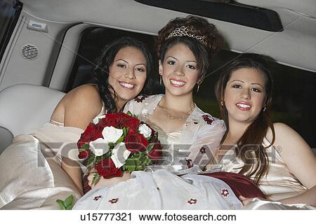 Stock Image - Girl (13-15) with friends in limousine at Quinceanera. Fotosearch