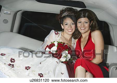 Stock Image - Girl (13-15) with mother in limousine at Quinceanera. Fotosearch
