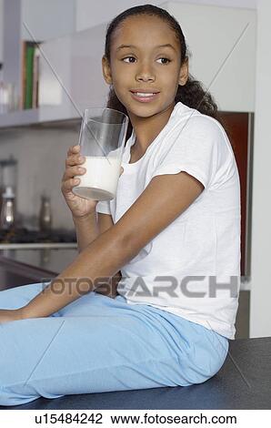 Girl (7-9) drinking milk, indoors View Large Photo Image Stock Image - Girl (7-9) drinking milk, indoors. Fotosearch