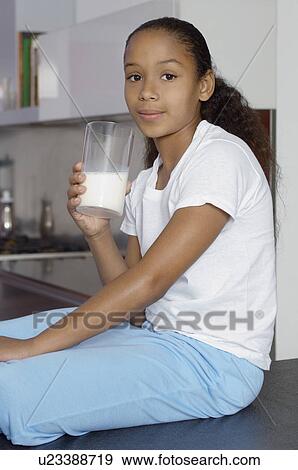 Stock Photo - Girl (7-9) drinking milk, indoors, portrait. Fotosearch