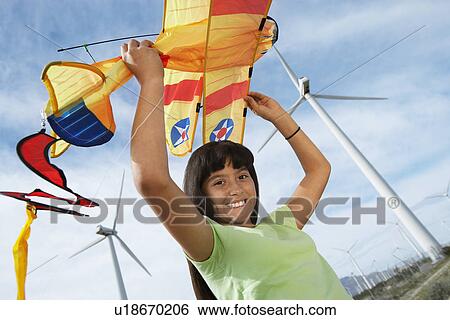 Girl (7-9) holding airplane kite at wind farm View Large Photo Image Stock Photograph - Girl (7-9) holding airplane kite at wind farm. Fotosearch