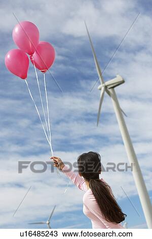 Girl (7-9) playing with balloons at wind farm View Large Photo Image Stock Image - Girl (7-9) playing with balloons at wind farm. Fotosearch