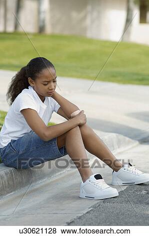 Stock Photo - Girl (7-9) sitting on curb. Fotosearch