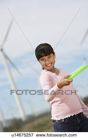 Girl (7-9) throwing disc at wind farm, portrait View Large Photo Image Stock Photo - Girl (7-9) throwing disc at wind farm, portrait. Fotosearch