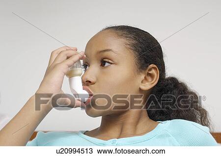 Stock Image - Girl (7-9) using inhaler in hospital. Fotosearch