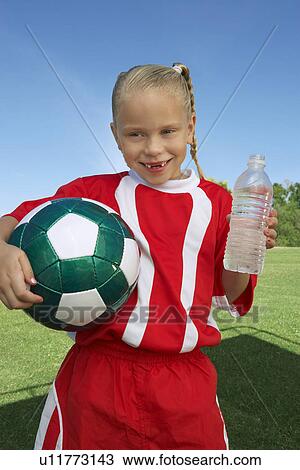 Girl (7-9 years) soccer player holding ball and water bottle, portrait View Large Photo Image Stock Image - Girl (7-9 years) soccer player holding ball and water bottle, portrait. Fotosearch