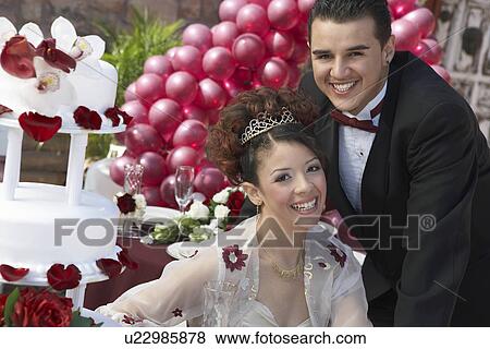 Stock Photo - Girl and boy (13-15) laughing at Quinceanera, portrait. Fotosearch