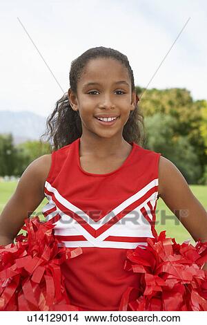 Picture - Girl cheerleader (7-9 years) standing on soccer field, portrait. Fotosearch