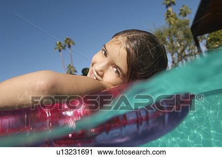 Girl floating in inflatable raft in swimming pool View Large Photo Image Stock Image - Girl floating in inflatable raft in swimming pool. Fotosearch