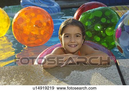 Girl in swimming pool with assortment of beach balls, portrait View Large Photo Image Stock Photo - Girl in swimming pool with assortment of beach balls, portrait. Fotosearch