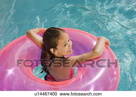 Stock Image - Girl Inside Pink Float Tube in Pool. Fotosearch